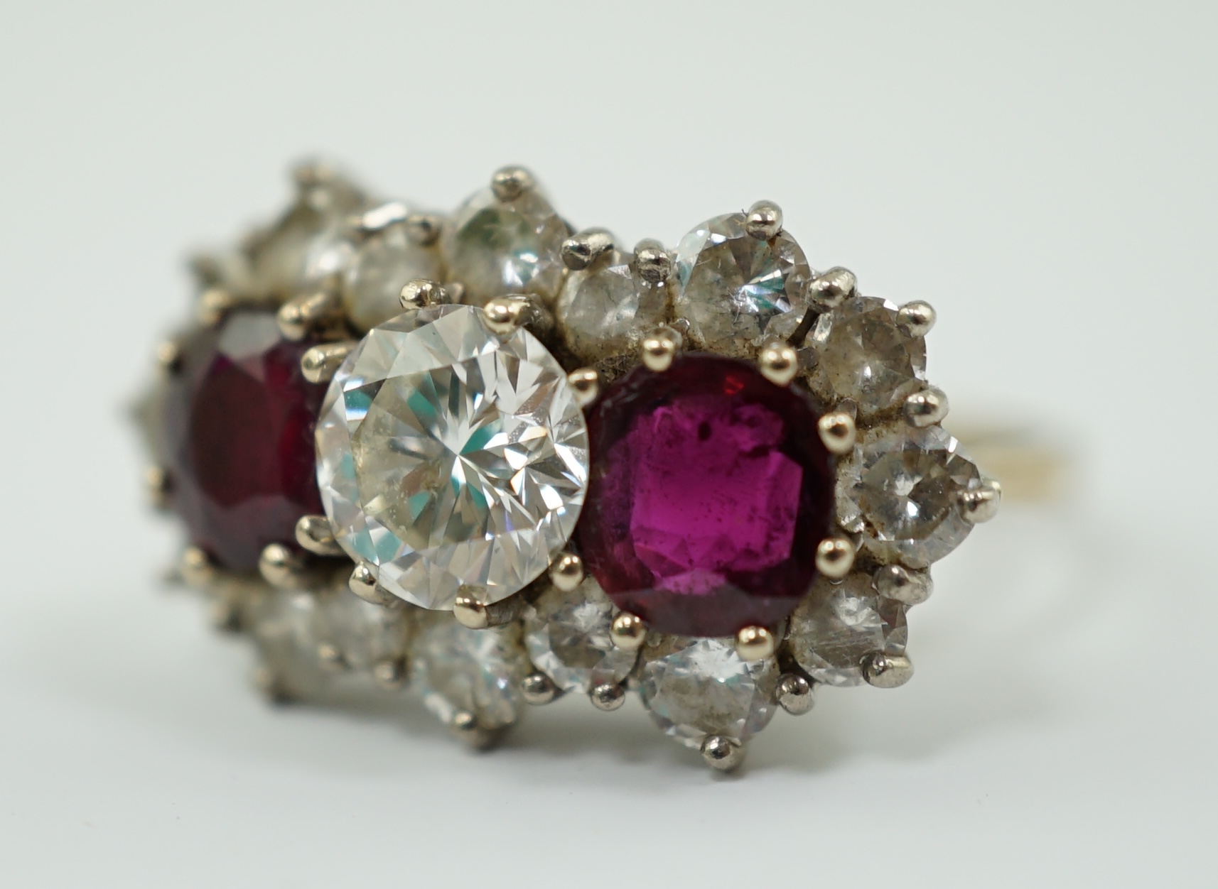 A 1970's 18ct white gold, ruby and diamond set triple cluster dress ring